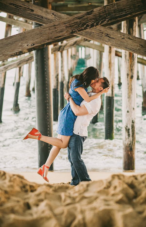 couple under the pier at the beach