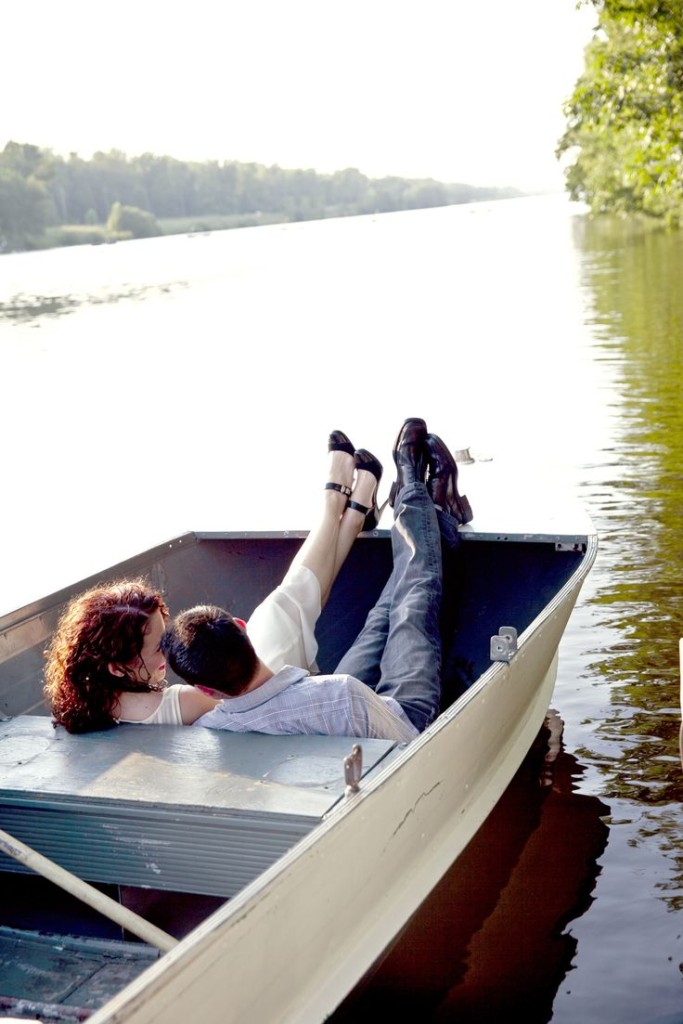 Couple relaxing in a rowboat during an engagement photo shoot