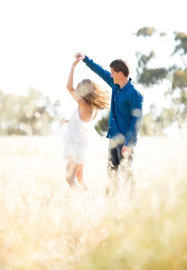 Couple dancing in a field for their engagement photo shoot