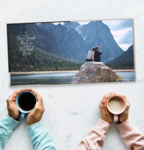 Anniversary photo book showing a couple sitting by a lake with coffee mugs held in front, celebrating love.