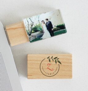 Personalized wooden USB drive featuring a wedding photo and a custom logo design.