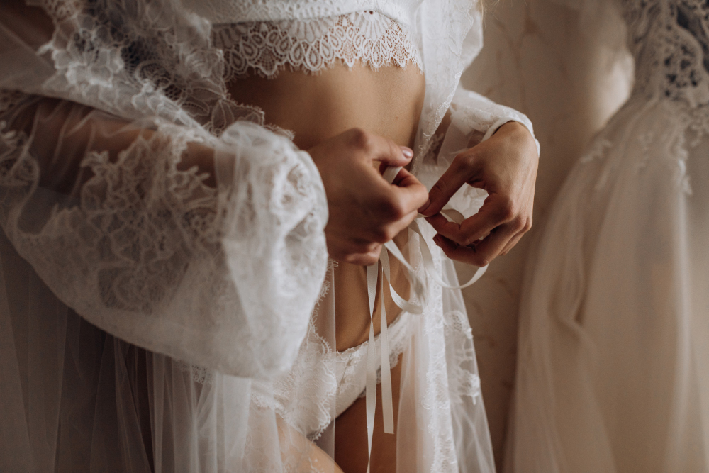 A woman in lace lingerie adjusting a ribbon, representing what boudoir photography means.