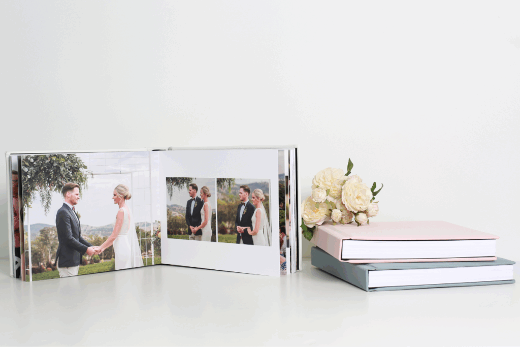 Open wedding album featuring a bride and groom holding hands at the altar, with additional wedding photos on the opposite page, and a bouquet of flowers nearby.