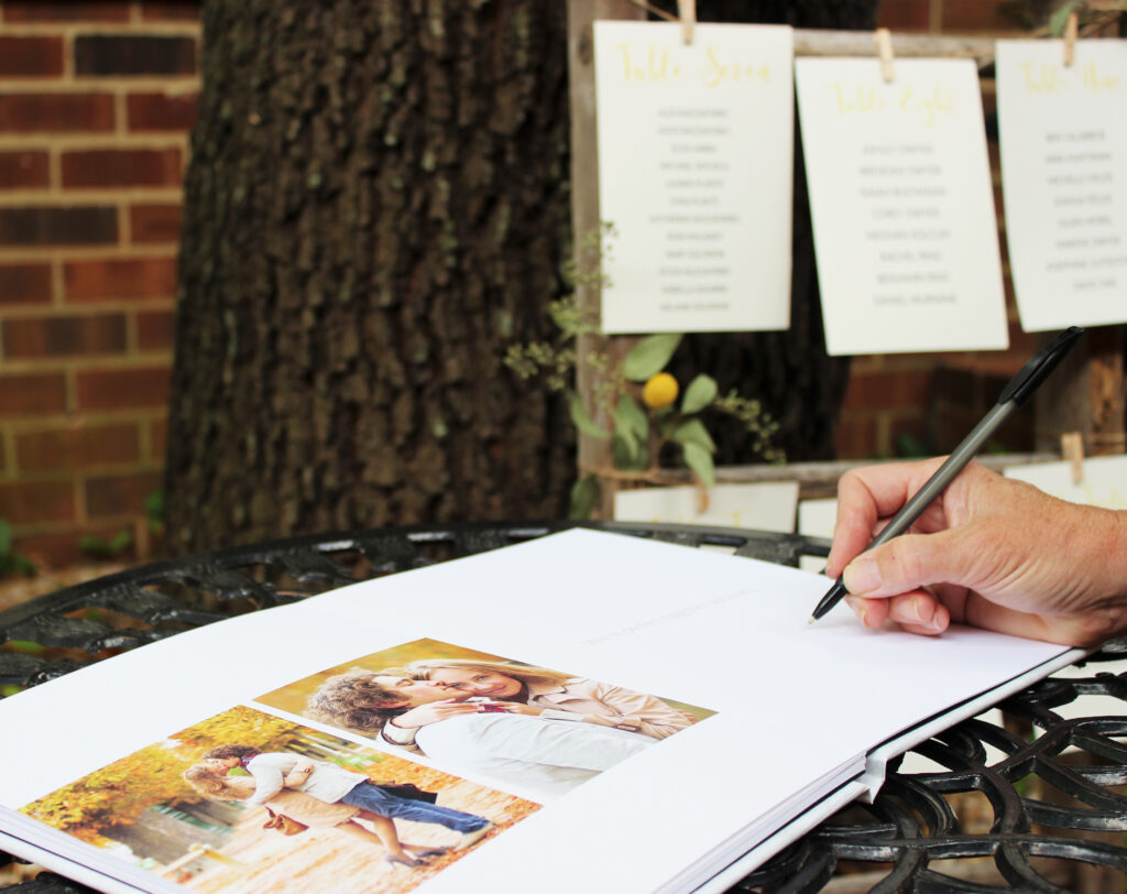 A person writing in a wedding guest book.
