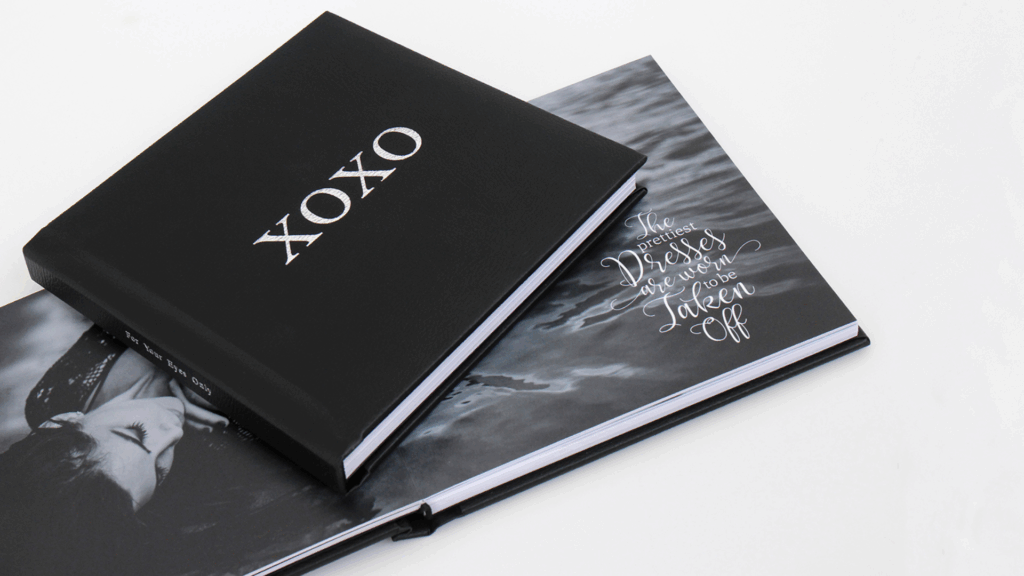 Two black photo albums with "XOXO" and "Dresses We Wore Taken Off" titles, featuring artistic images inside.